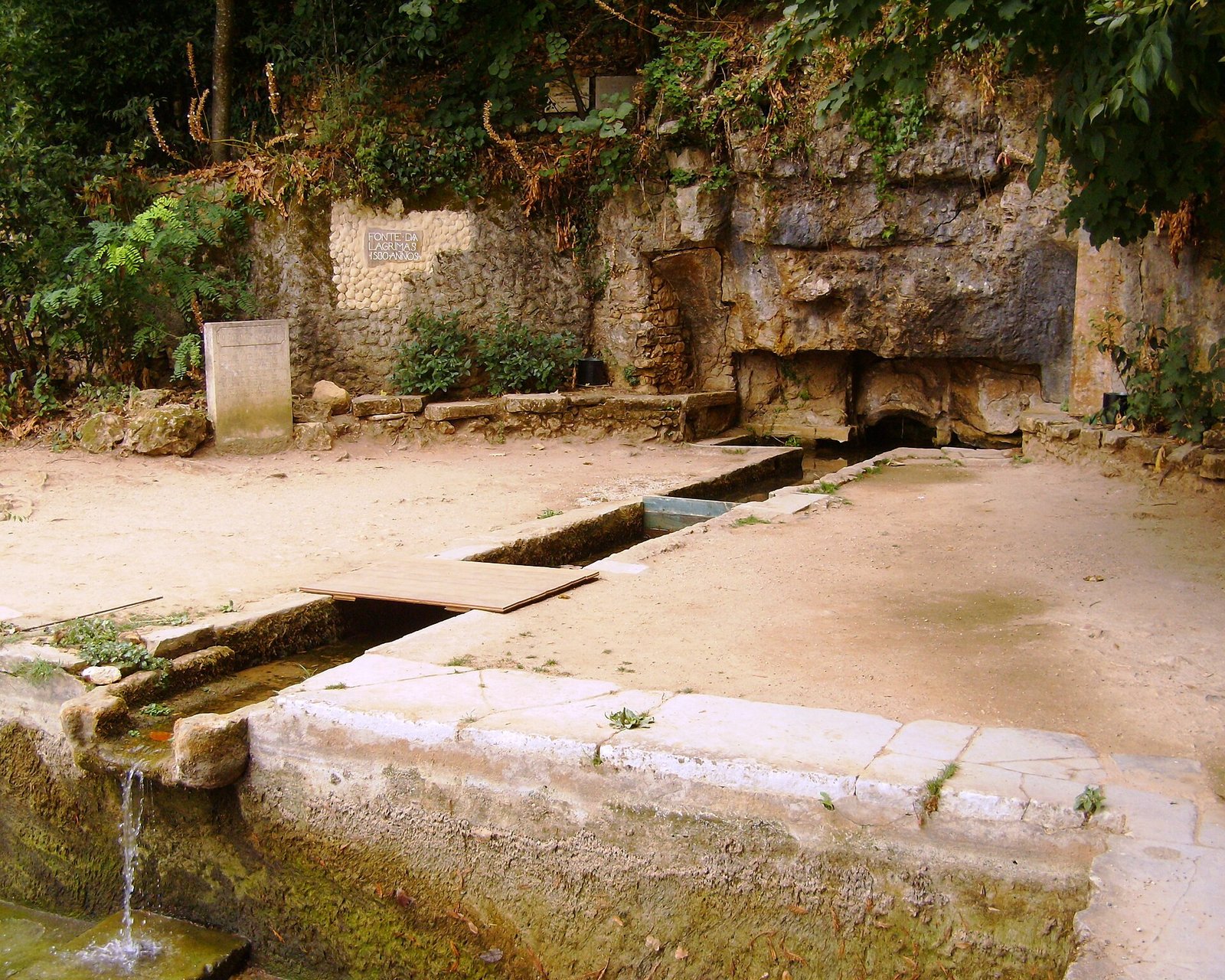 The stone structure and water of Fonte das Lágrimas in the gardens of Quinta das Lágrimas