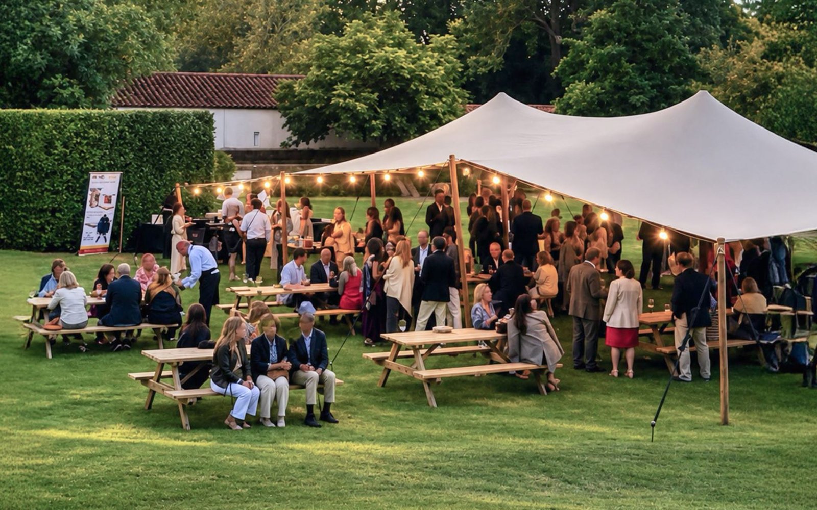 Outdoor Garden Party tables and a tented gathering area in the gardens of Quinta das Lágrimas